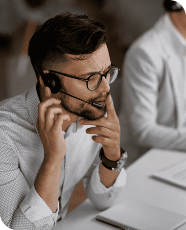 concentrated-call-center-agent-talking-with-customer-while-working-office (1)