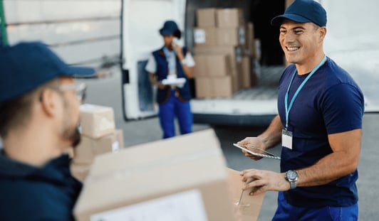 happy-manual-worker-using-touchpad-while-communicating-with-his-coworker-organizing-package-delivery