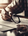 young-businessman-analyzing-data-holding-magnifying-glass-generated-by-ai